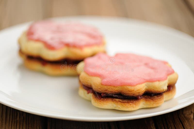 Two Round Double Sand Cakes Decorated with Pink Icing and Jam on Stock