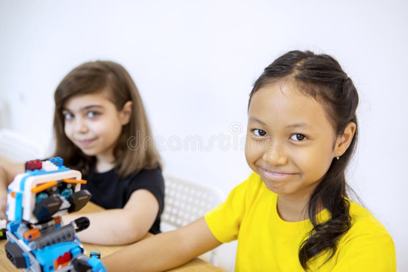 Two schoolgirls constructing a Lego robot stock photography