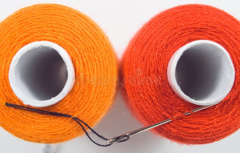 two sewing spools with a needle