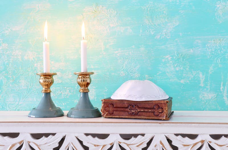 Two Shabbat Candlesticks with Burning Candles Over Wooden Table Stock