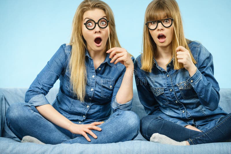 Two shocked women holding fake eyeglasses on stick stock photography Two shocked women holding fake eyeglasses on stick stock photography