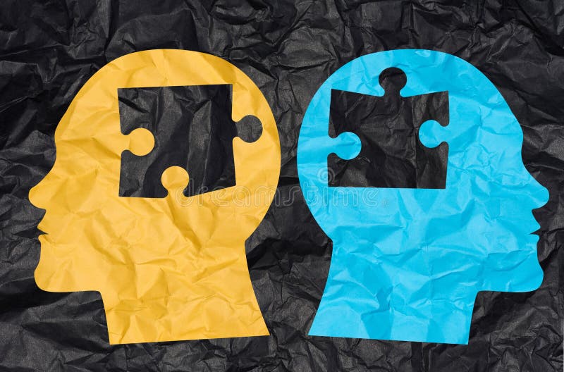 Two silhouettes of heads cut out from crumpled paper with puzzle pieces. Concept of similarity among people, finding a match