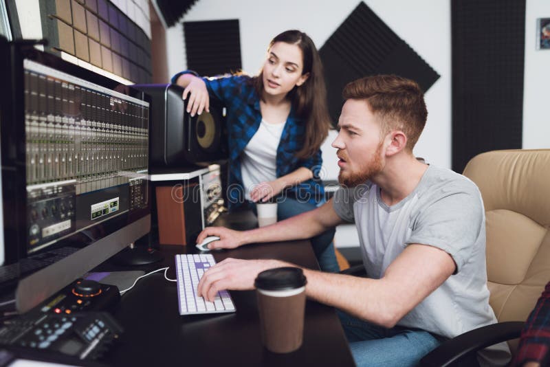 Two singers and sound engineers in the recording studio.