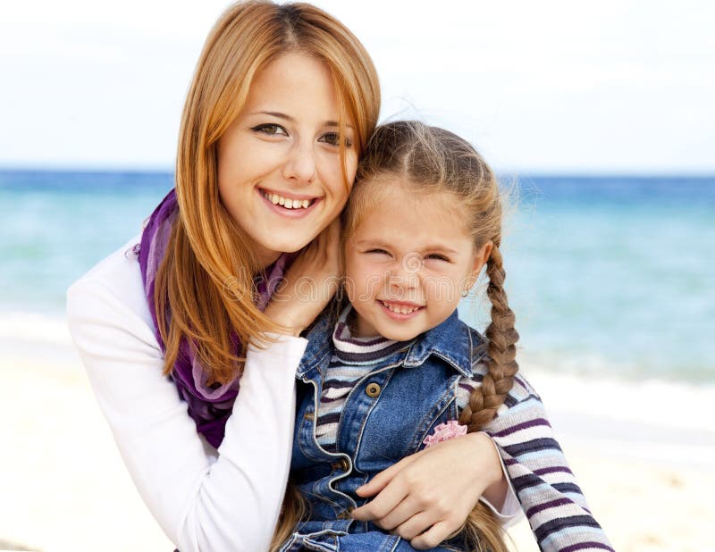 Two sisters at the beach in sunny autumn day