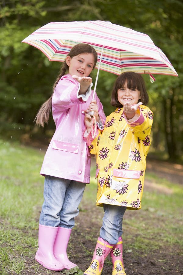 Two Sisters Outdoors in Rain with Umbrellas Stock Image - Image of ...