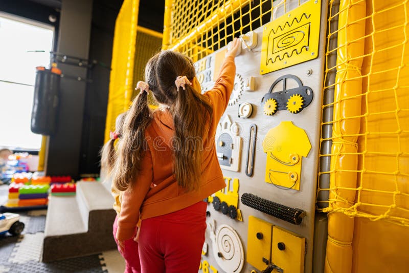 Two Sisters Playing with Busy Board at Kids Play Center Stock Image