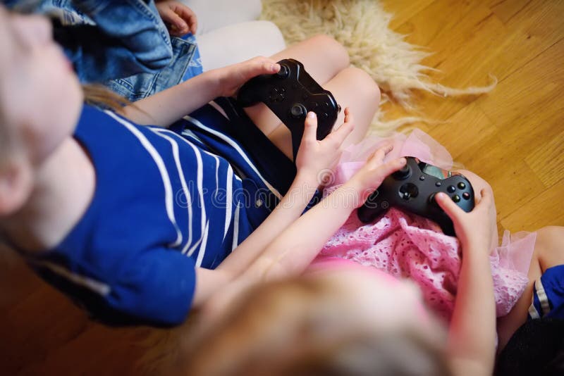 Two sisters play games - a Royalty Free Stock Photo from Photocase