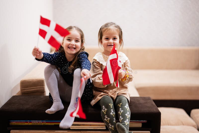 Two Sisters are Sitting on a Couch at Home with Danish Flags on Hands ...