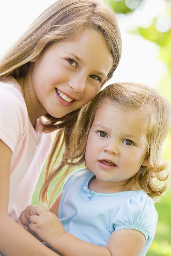 Two Sisters Sitting Outdoors Smiling Stock Image Image Of Affection 