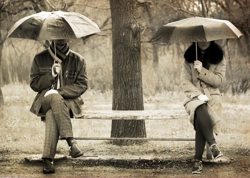 Two sitting at bench in rainy day.
