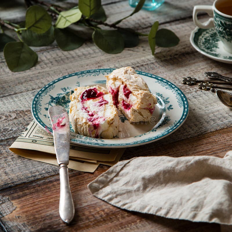 Two slices of homemade meringue roll with cream and berries