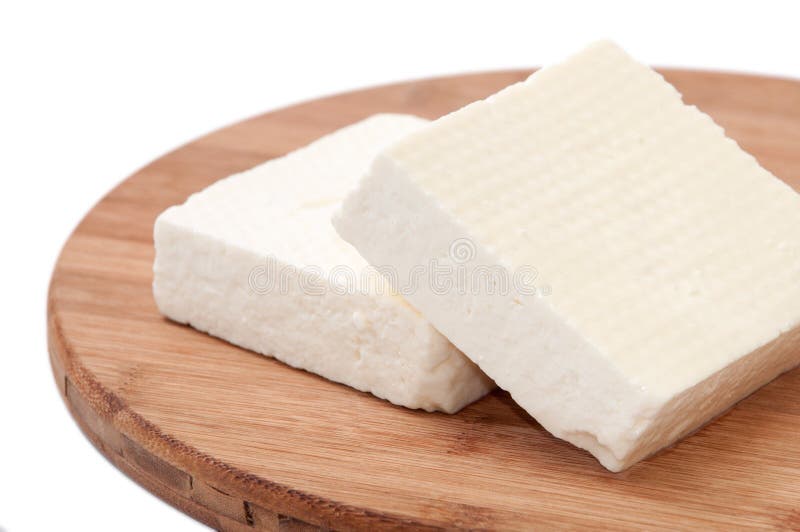 Two slices of white feta cheese on a kitchen board