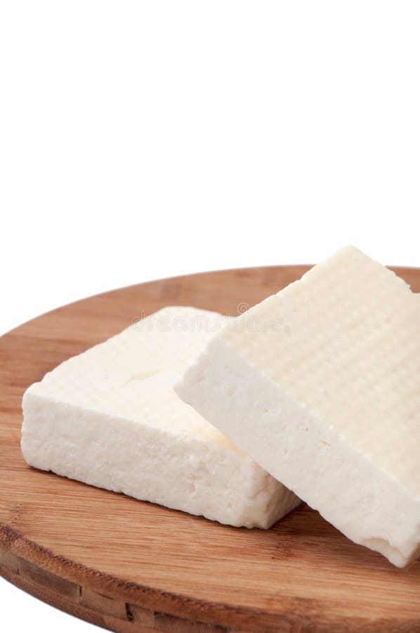 Two slices of white feta cheese on a kitchen board