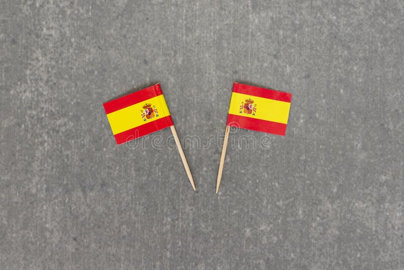 Two Small Spain Flags on Grey Background royalty free stock photography