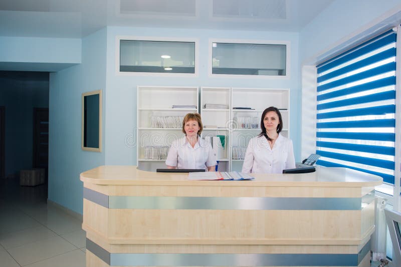 Two smiling nurses working at hospital reception desk stock photos Two smiling nurses working at hospital reception desk stock photos