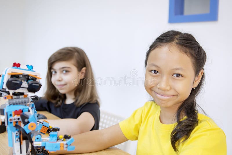 Two smiling students with a Lego robot in class stock photos.