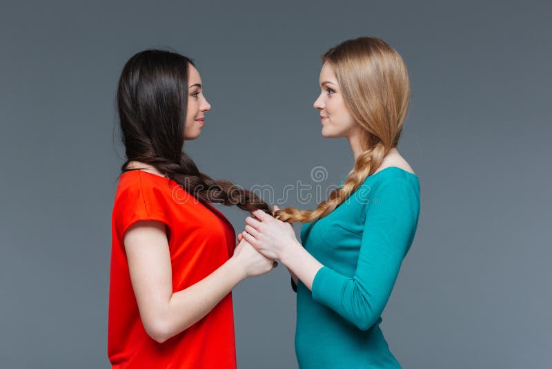 Two smiling women holding hands and looking on each other