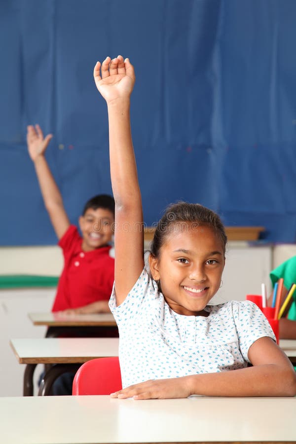 Two smiling young school children arms raised in c