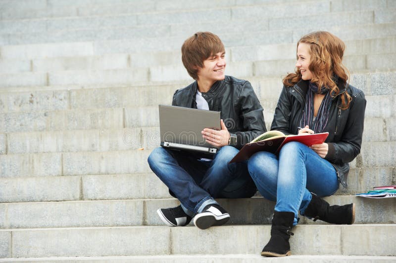 Two smiling young students outdoors royalty free stock image