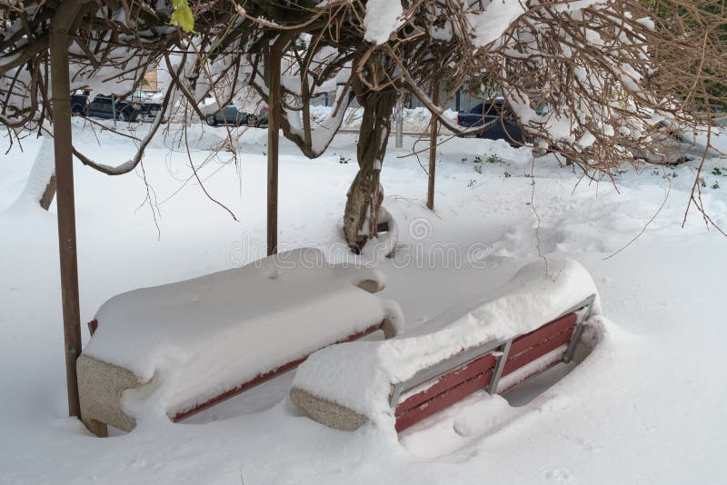 Two snow covered benches stock photo