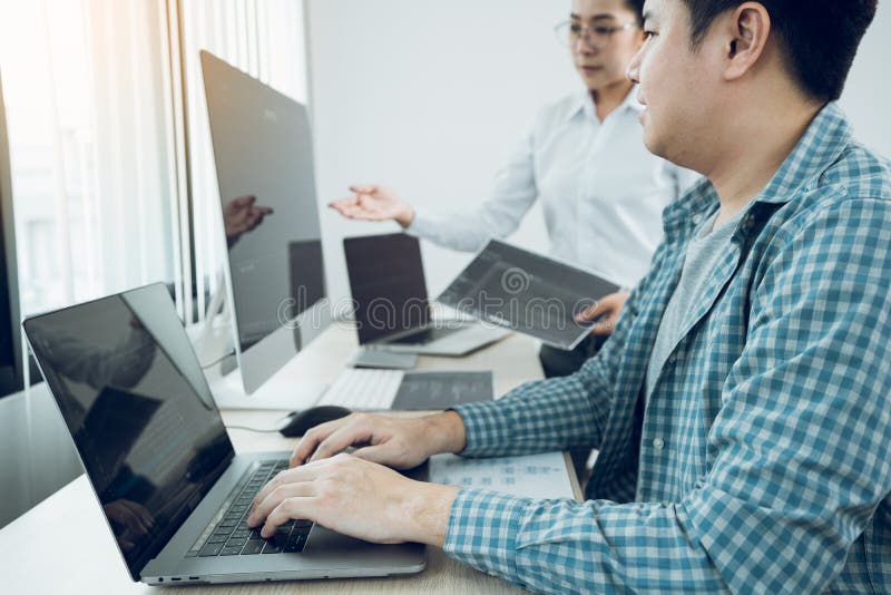 Two software developers are analyzing together about the code written into the program on the computer in office room stock photo