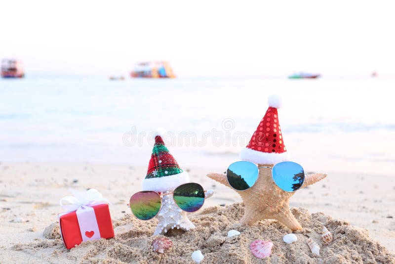 Two starfish on sea beach with sunglasses and santa hat for Merry Christmas and New Years royalty free stock photography Two starfish on sea beach with sunglasses and santa hat for Merry Christmas and New Years royalty free stock photography