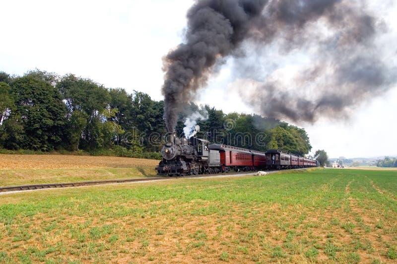 Ein Blick auf zwei altmodische Dampf-Lokomotiven und Züge, als Sie aneinander vorbei entlang einer Strecke durch die Landschaft in Straßburg, Pennsylvania (USA)