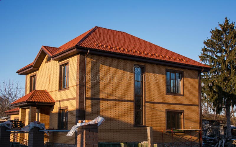 Two-storey house with tall vertical window narrow vertical window, rectangular windows, rain gutters and snow guards stock image Two-storey house with tall vertical window narrow vertical window, rectangular windows, rain gutters and snow guards stock image