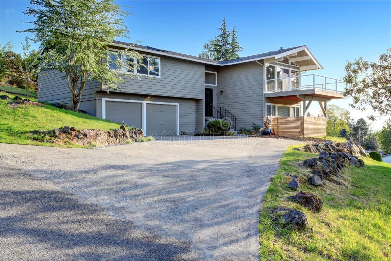 Two story house exterior with gray siding and concrete driveway.