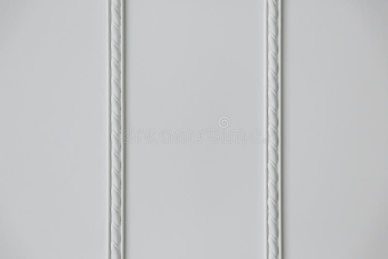 Two strips of embossed stucco molding on a white wall, close up. Two strips of embossed stucco molding on a white wall, close up