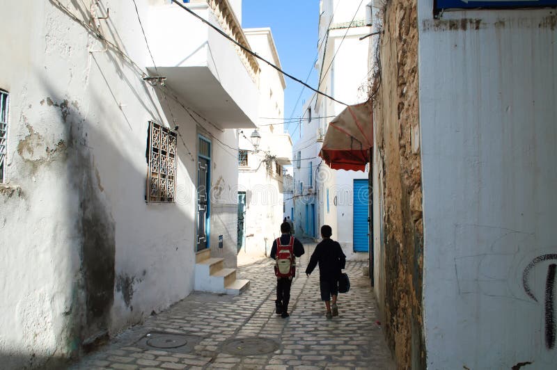 Two students go to school on the street of the old town of Sousse royalty free stock photography Two students go to school on the street of the old town of Sousse royalty free stock photography