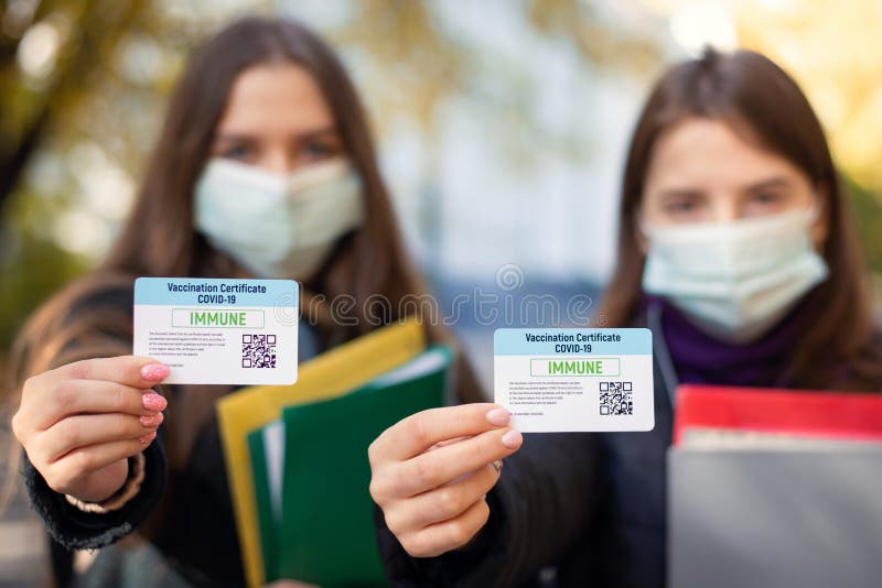 Two students showing vaccination certificates cards to the camera, focus on certicites royalty free stock image Two students showing vaccination certificates cards to the camera, focus on certicites royalty free stock image