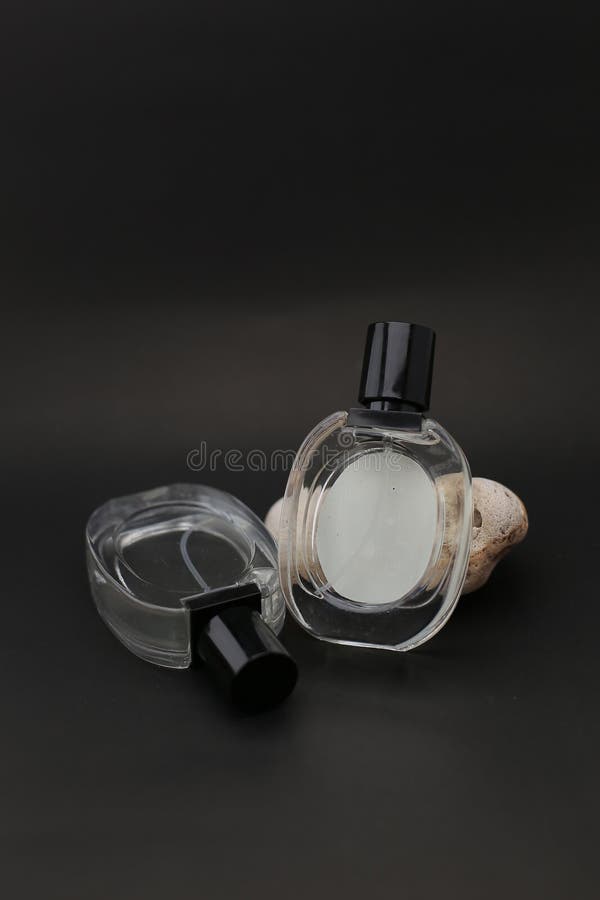 Elegant Transparent Perfume Bottles with Black Caps on Dark Background royalty free stock photo