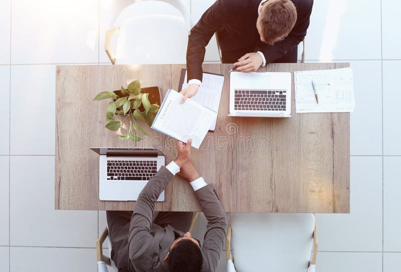 Two successful smiling businessmen are working on a laptop. view from above royalty free stock photography