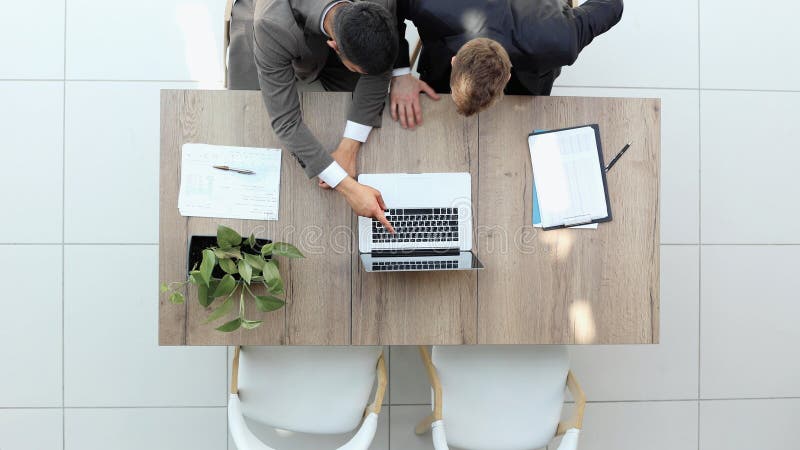 Two successful smiling businessmen are working on a laptop. view from above stock photo