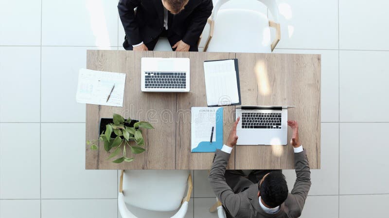 Two successful smiling businessmen are working on a laptop. view from above stock image
