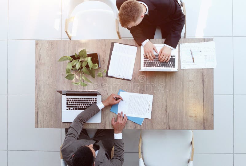 Two successful smiling businessmen are working on a laptop. view from above royalty free stock photo