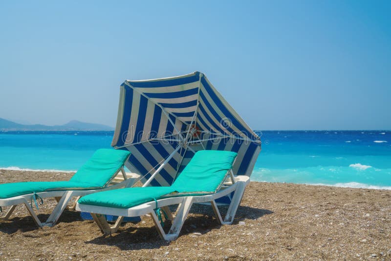 Two Sunbeds on the Sandy Beach Against Sea. Stock Photo Image of