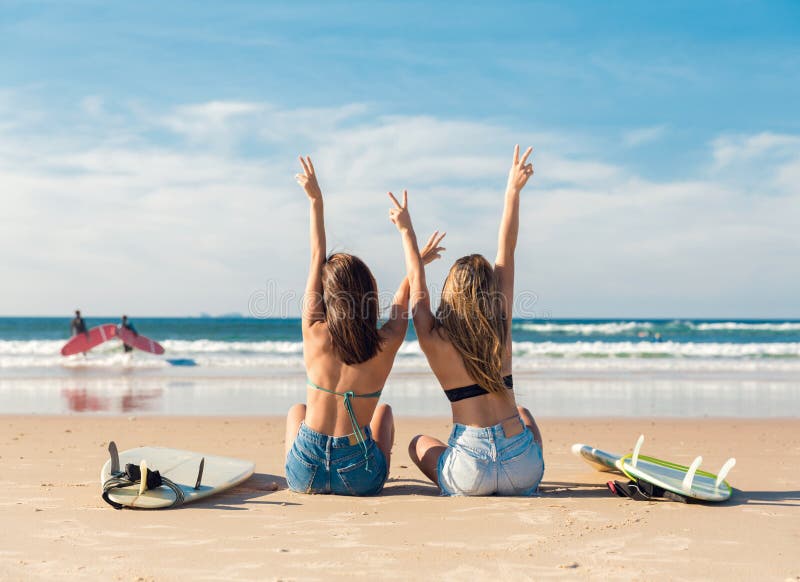 Two surfer girls at the beach stock photo Two surfer girls at the beach stock photo