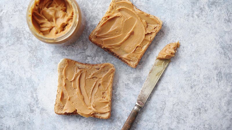 Two tasty peanut butter toasts placed on stone table
