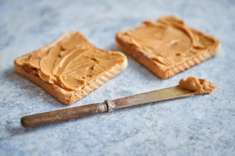 Two tasty peanut butter toasts placed on stone table