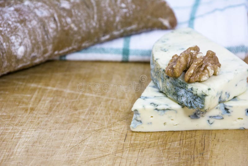 Two tasty pieces of cheese roquefort with bread and walnut on wooden background royalty free stock photo Two tasty pieces of cheese roquefort with bread and walnut on wooden background royalty free stock photo
