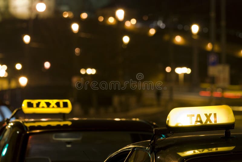 Two taxi signs at night