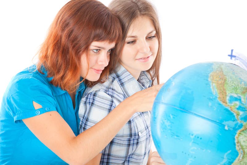 Two teen-girls are looking at globe