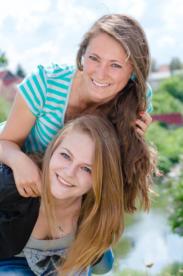 Two Teen Girl Friends Laughing having fun in spring or summer outdoors background. Two Teen Girl Friends Laughing having fun in spring or summer outdoors background