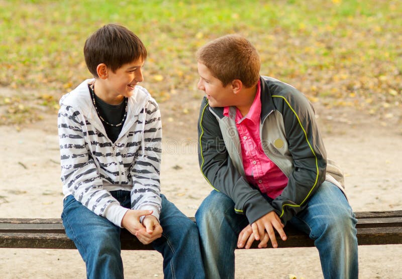 Two Teenage Friends Talking In The Park Stock Photo Image Of Bench