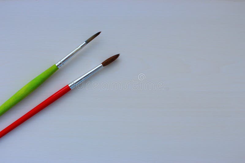 Two Thin Red and Green Paintbrushes on White Background As Drawing