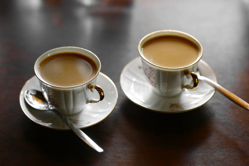 Two Tiny Coffee Cup with Hot Milk Coffee and Teaspoons Stock Image