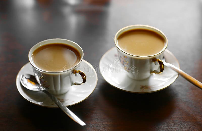 Two Tiny Coffee Cup with Hot Milk Coffee and Teaspoons Stock Photo