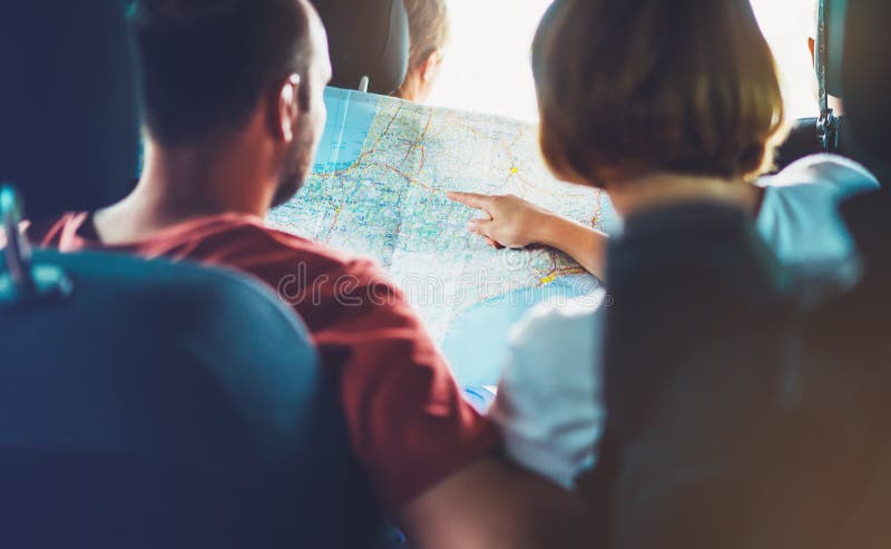 Two tourist traveler together hold in hands europe cartography, view and plan tourist way road, trip in transportation, couple hipster friends looking and point finger on location navigation map in auto car